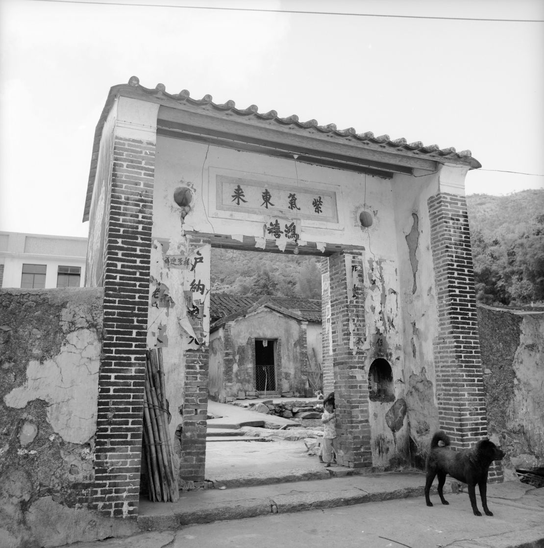 A child stands barefoot at the village gate in 1976.